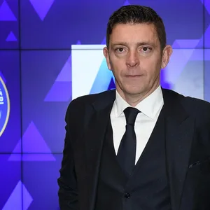Gianluca Rocchi vor einer blauen Wand mit Italien Logo
