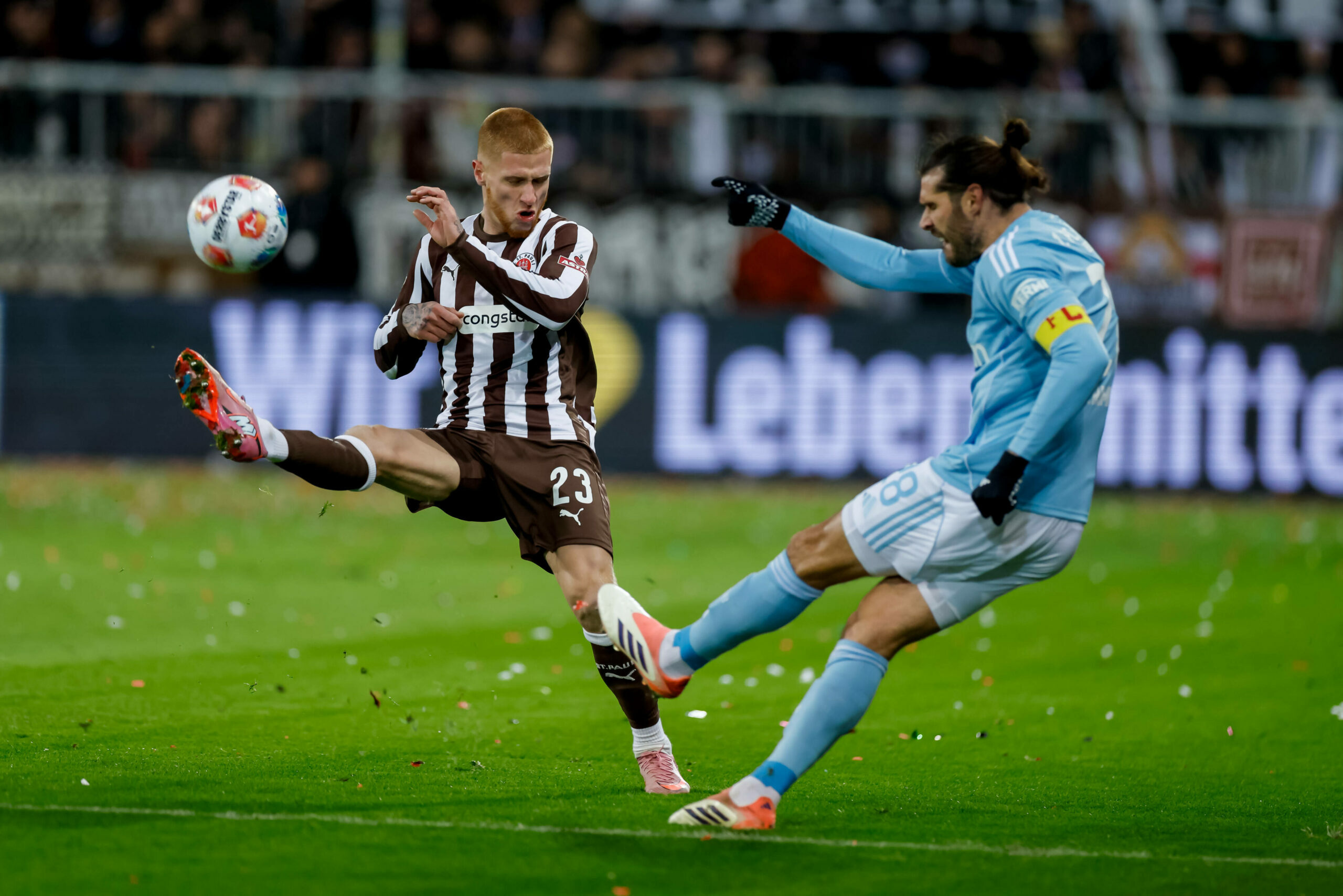 St. Pauli-Spieler Louis Oppie versucht artistisch einen Schuss des Berliners Christopher Trimmel abzublocken
