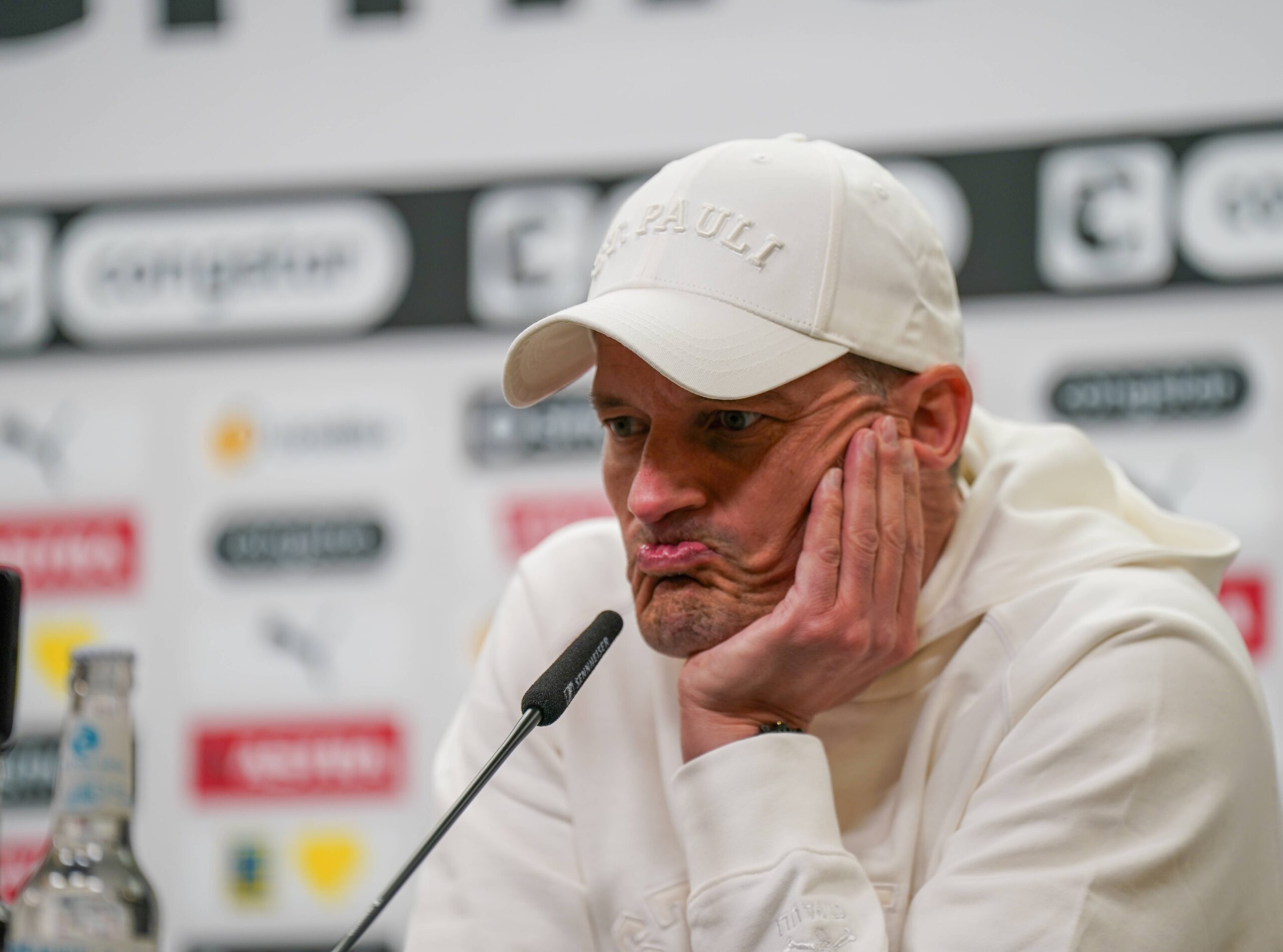 St. Pauli-Trainer Alexander Blessin mit grübelndem Gesichtsausdruck bei einer Pressekonferenz