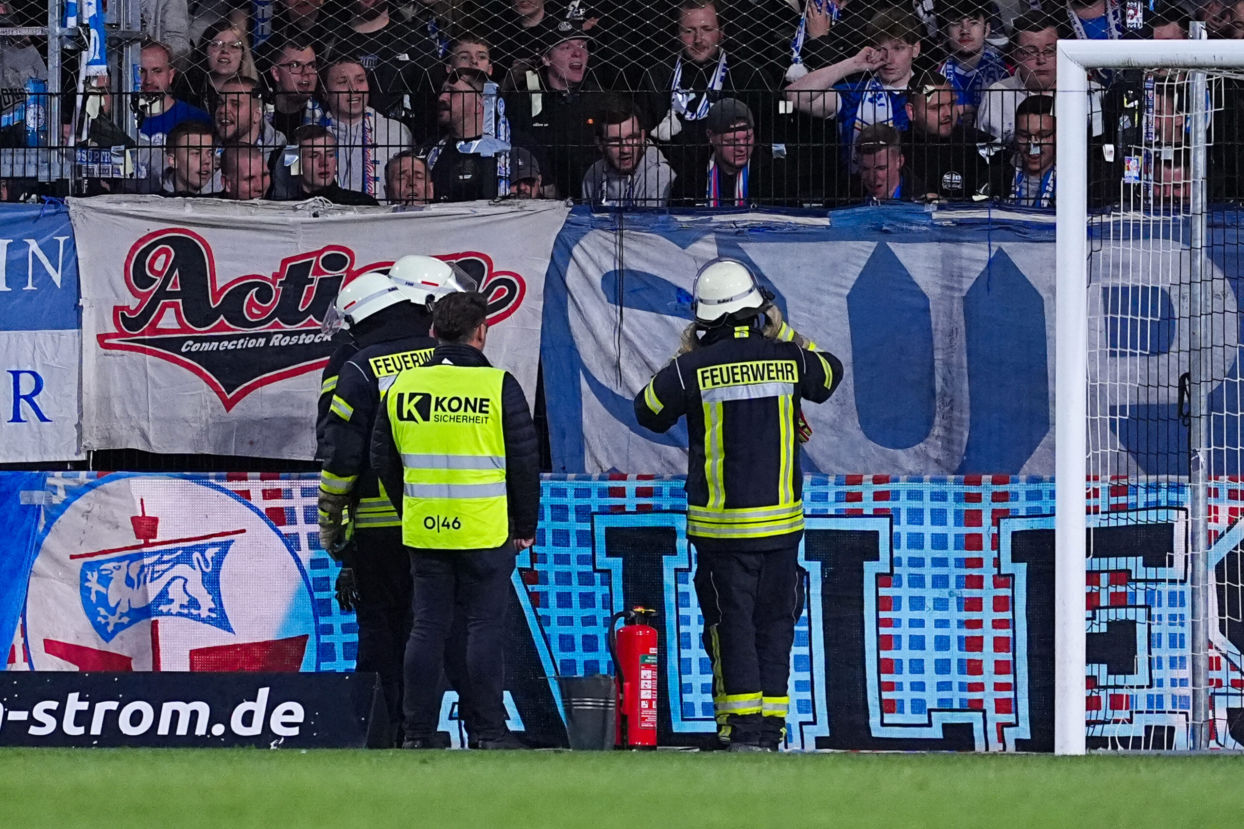 Die Feuerwehr steht vor den Rostocker Gästefans