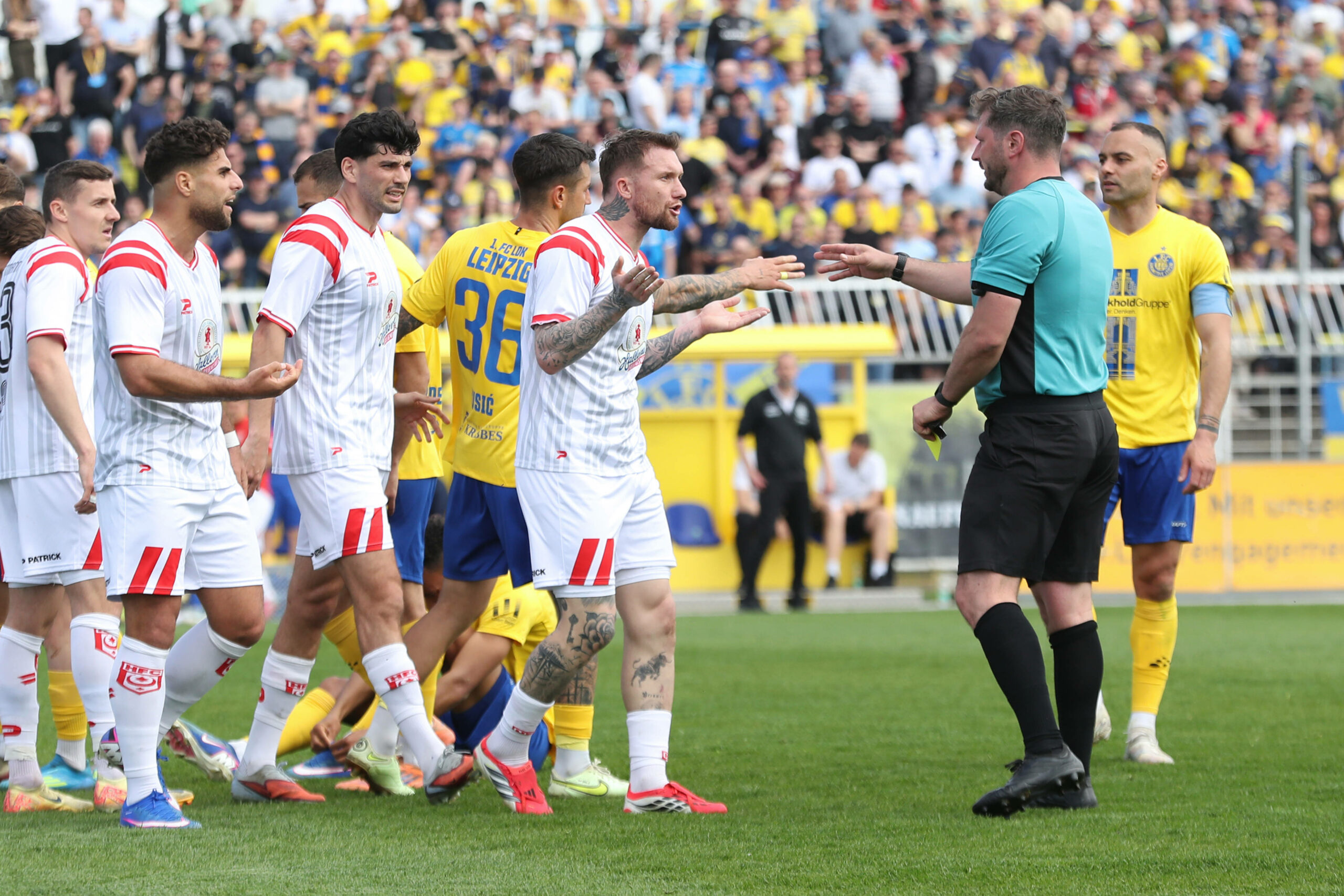 Die Regionalliga-Spieler von Lokomotive Leipzig diskutieren mit dem Schiedsrichter