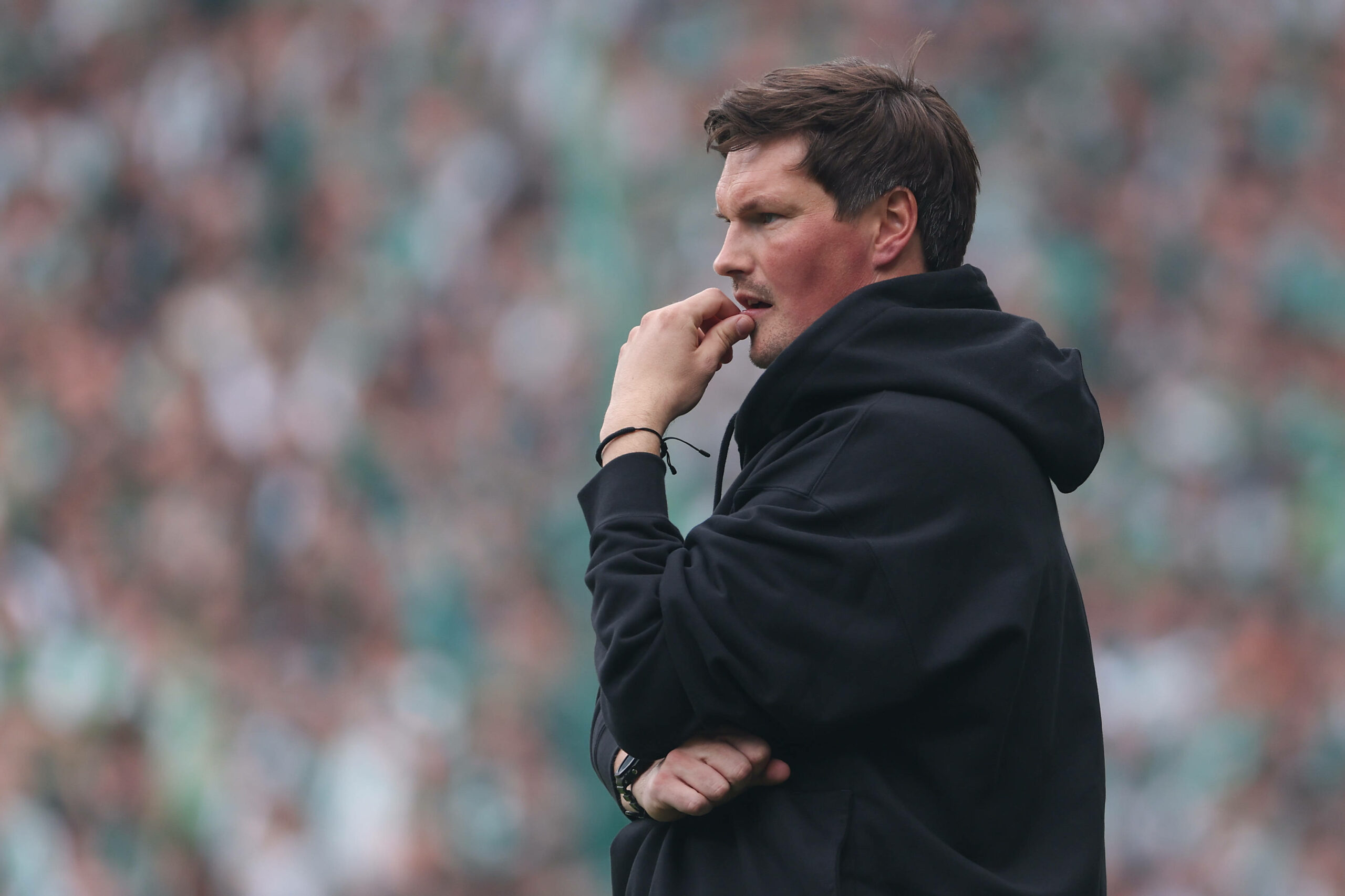 HSV-Trainer Merlin Polzin hält sich die Hand an den Mund und schaut nachdenklich.
