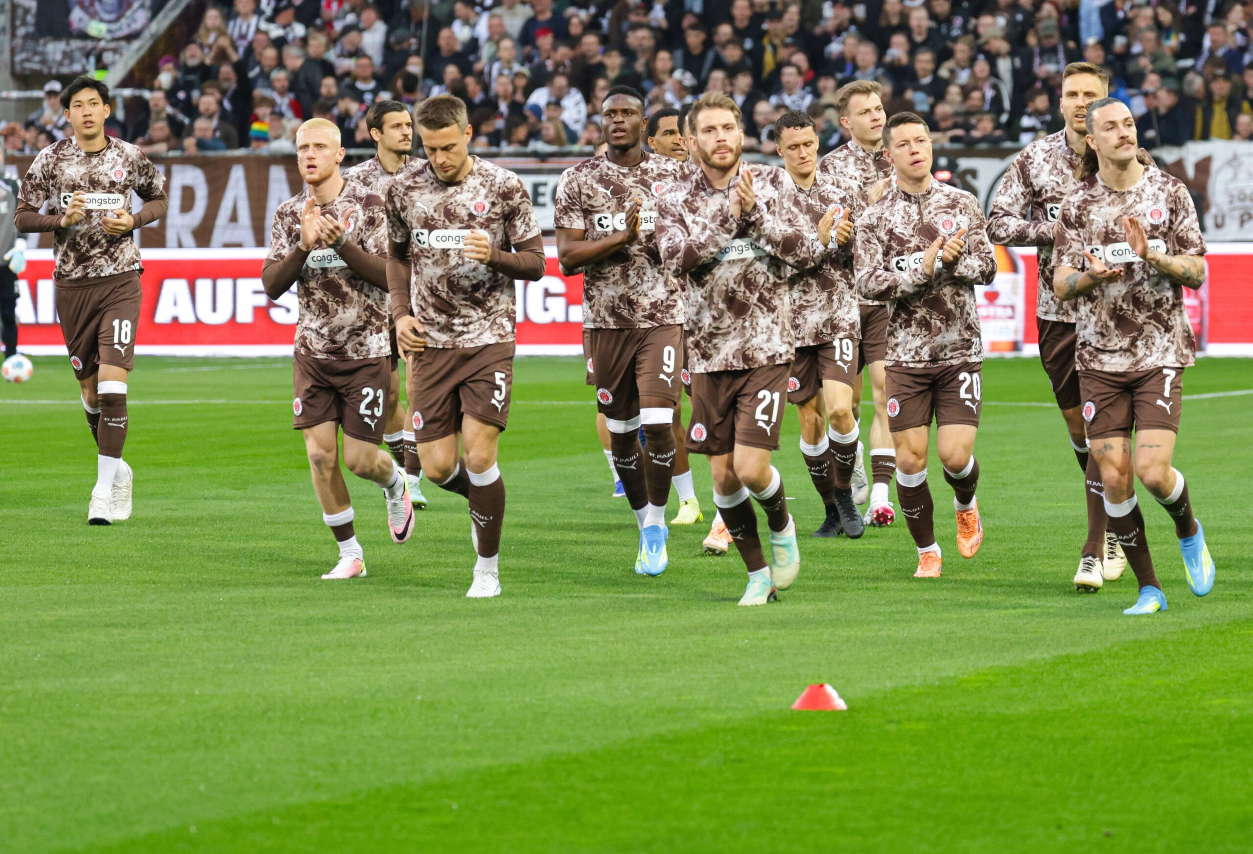 St. Paulis Profis kommen zum Aufwärmen auf den Platz
