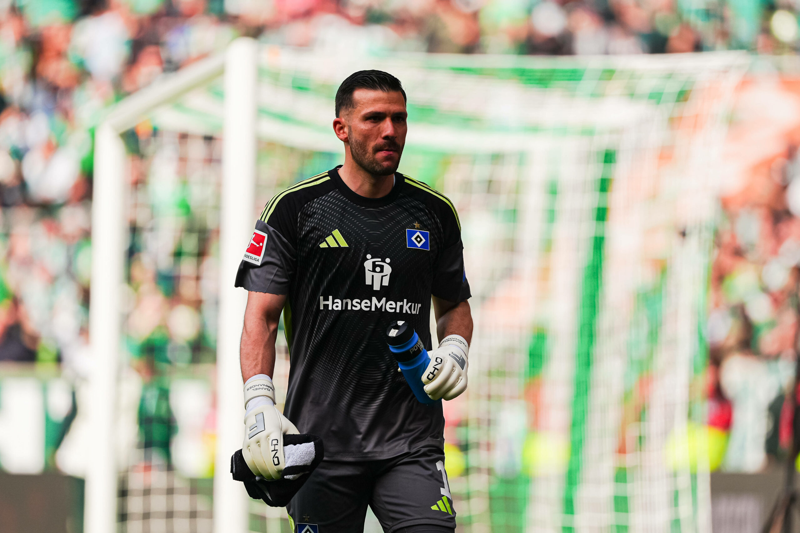 Daniel Heuer Fernandes mit Flasche in der Hand auf dem Spielfeld