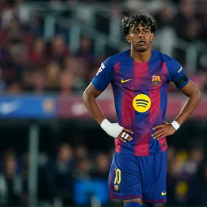 Lamine Yamal steht mit in die Hüften gestützten Händen auf dem Platz