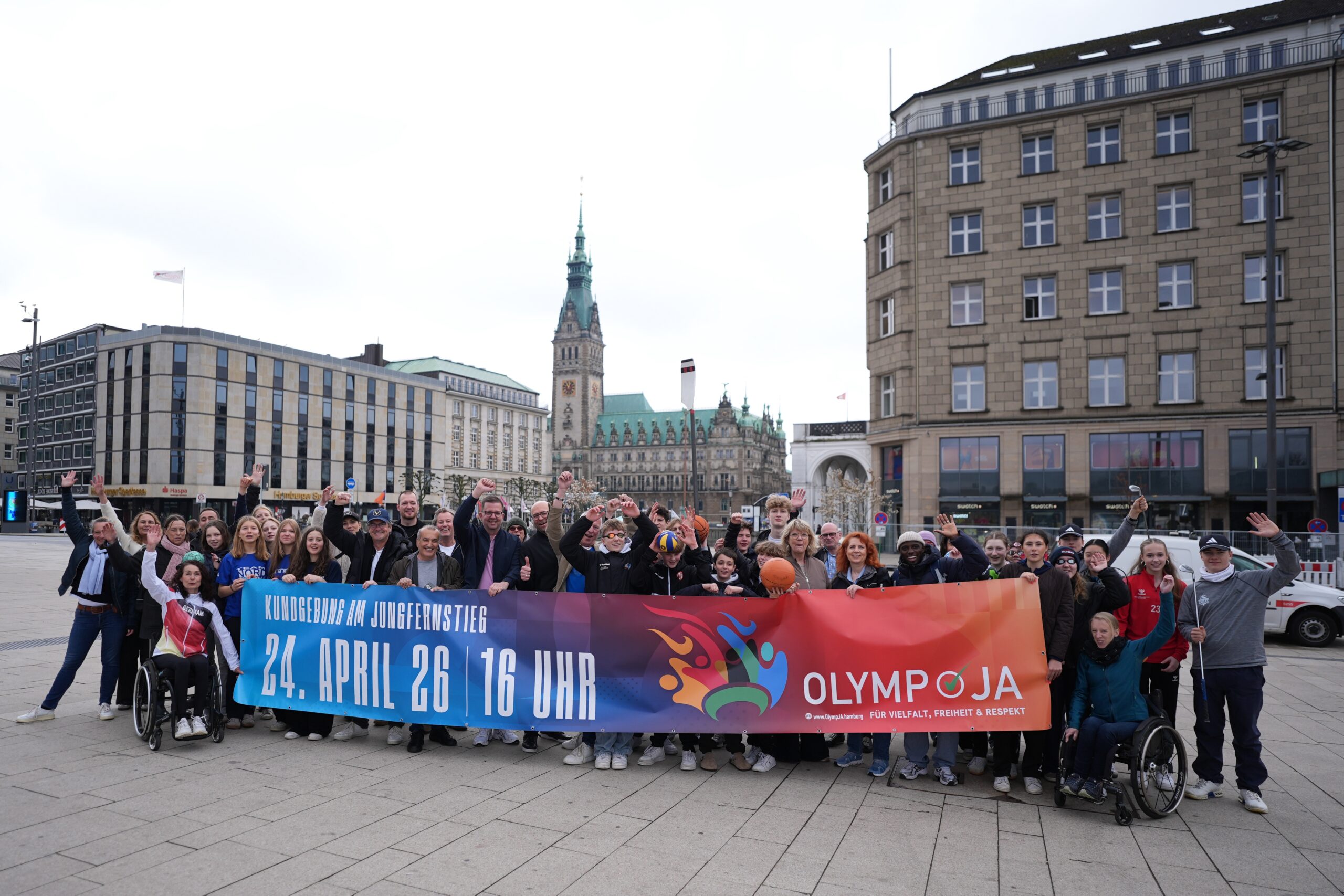 Die Mitglieder der Initiative „OlympJA Hamburg“ stehen mit einem Plakat auf der Reesendammbrücke am Jungfernstieg in der Innenstadt.