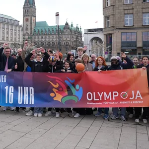 Die Mitglieder der Initiative „OlympJA Hamburg“ stehen mit einem Plakat auf der Reesendammbrücke am Jungfernstieg in der Innenstadt.