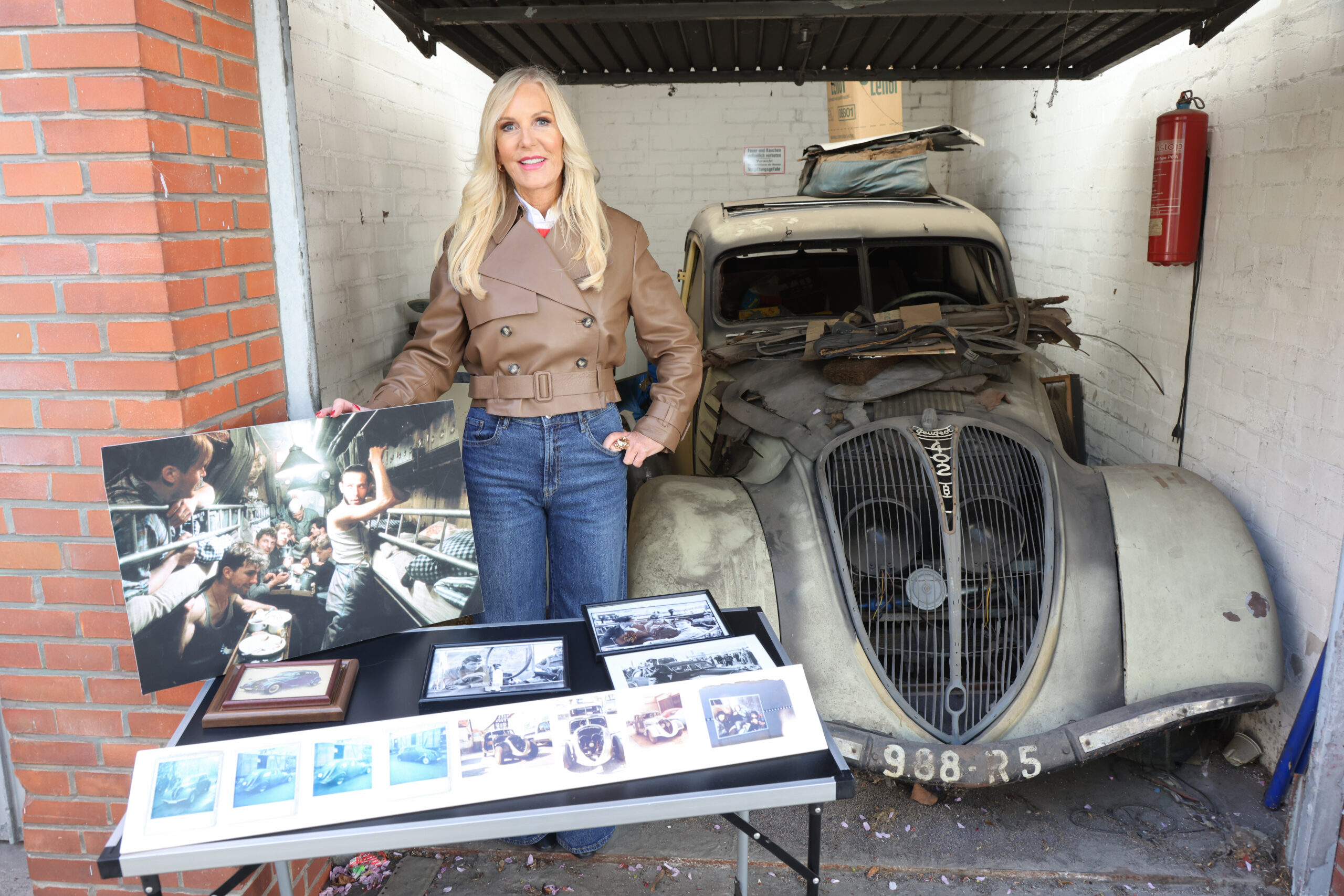 Marion Fedder, Witwe des gestorbenen Hamburger Schauspielers Jan Fedder, steht vor einem alten Peugeot 402.