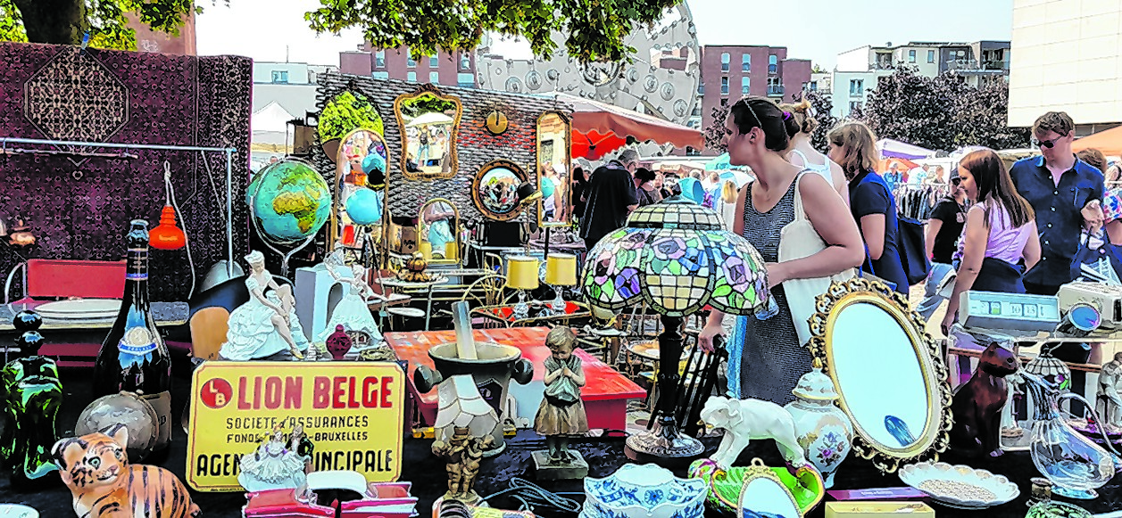 Menschen gehen über einen Flohmarkt.