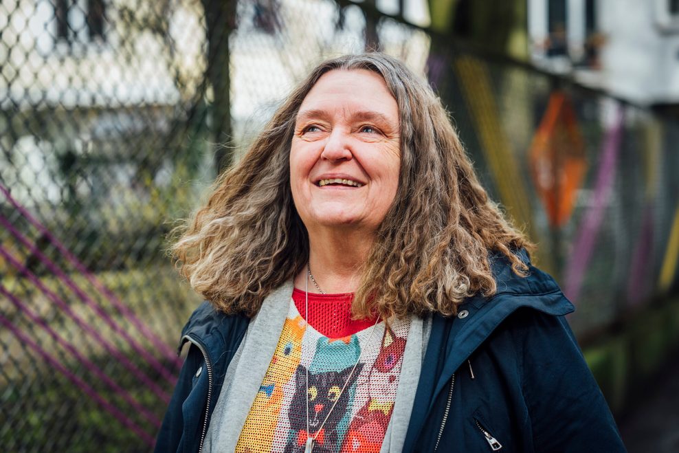 Frau mit schulterlangen grauen Haaren lächelt