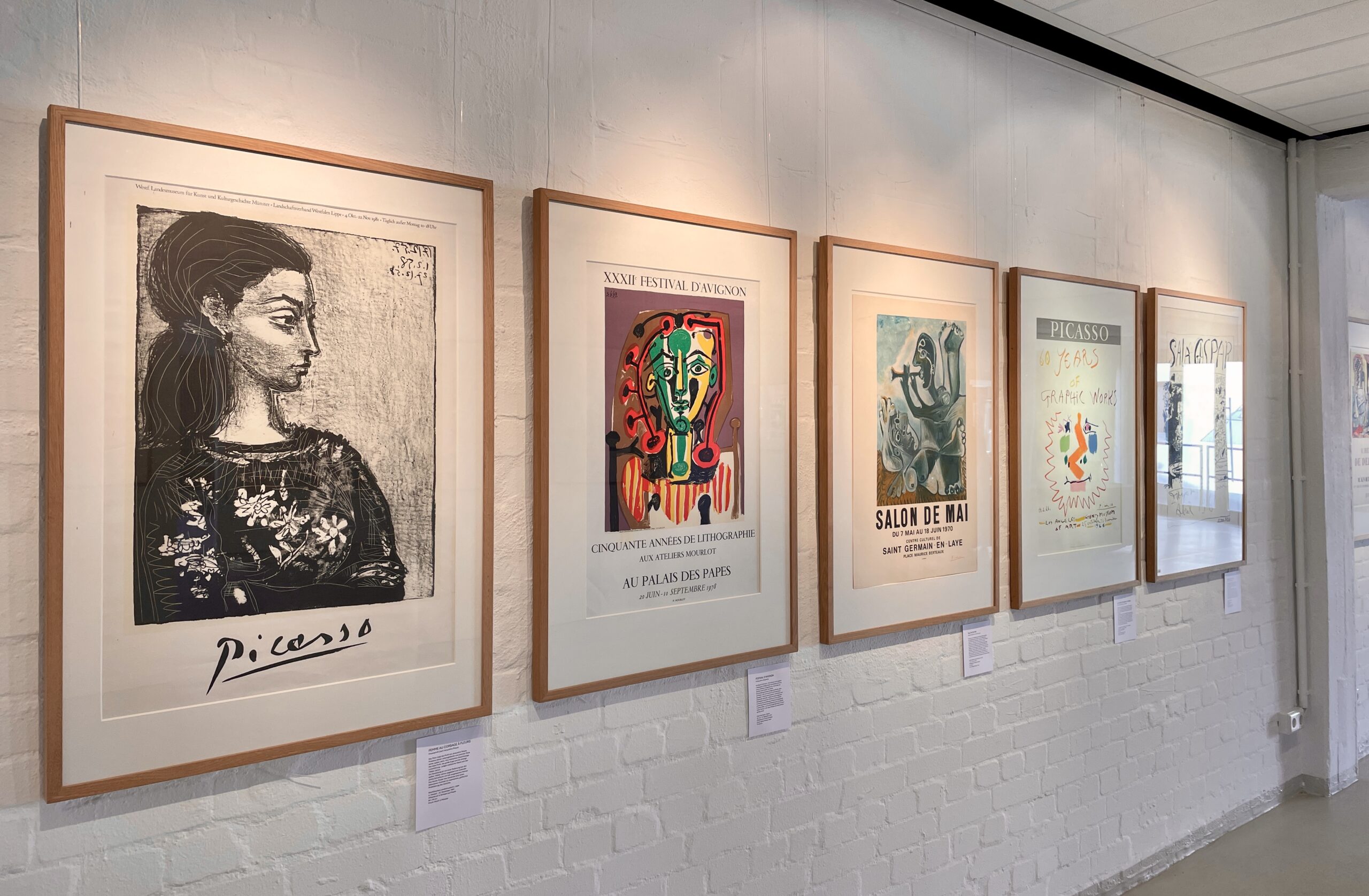 Plakate und Lithografien von Picasso hängen gerahmt an einer weißen Wand.