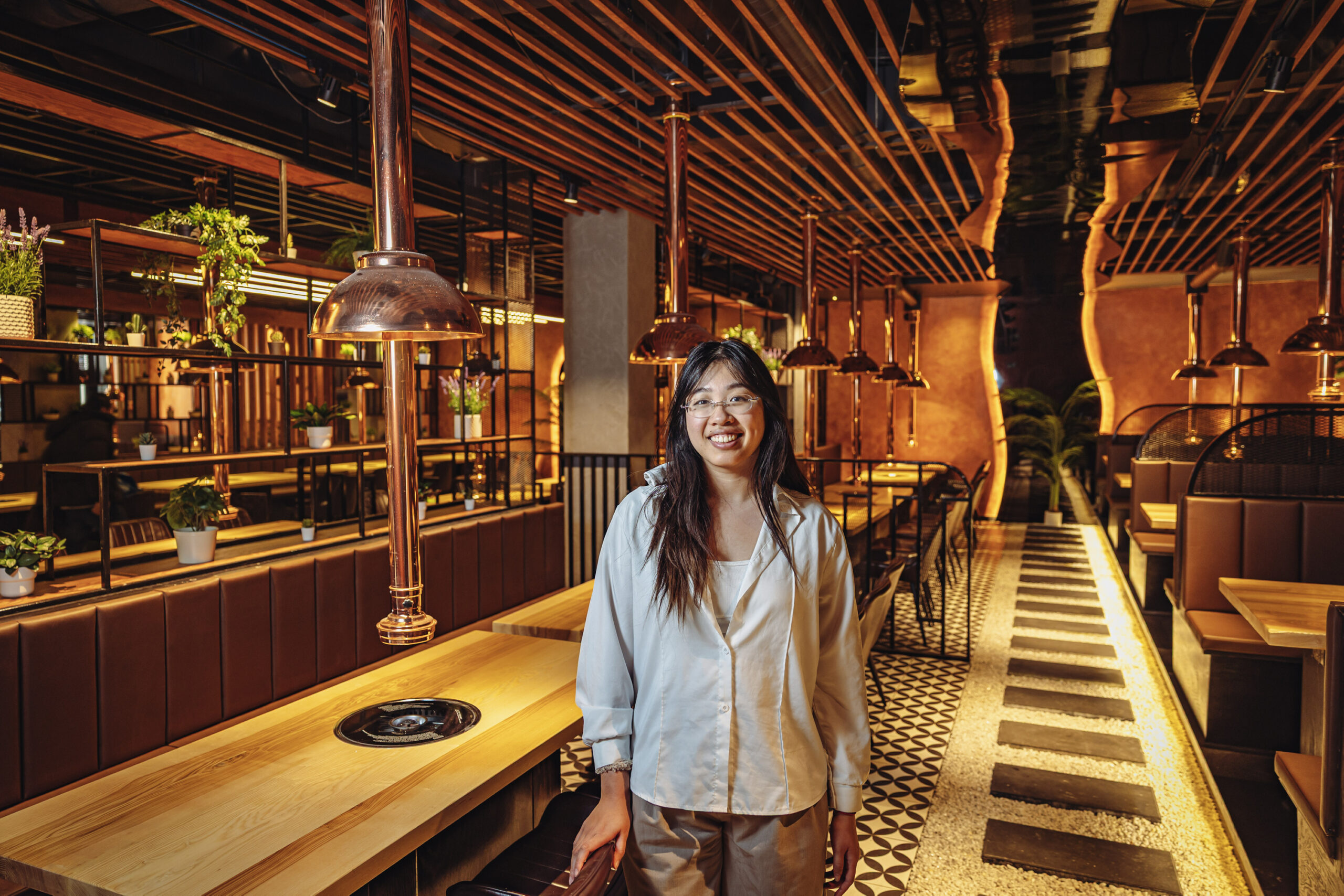 Restaurant-Managerin Ivy Nguy (23) zeigt den Grill- und Hotpot-Bereich.