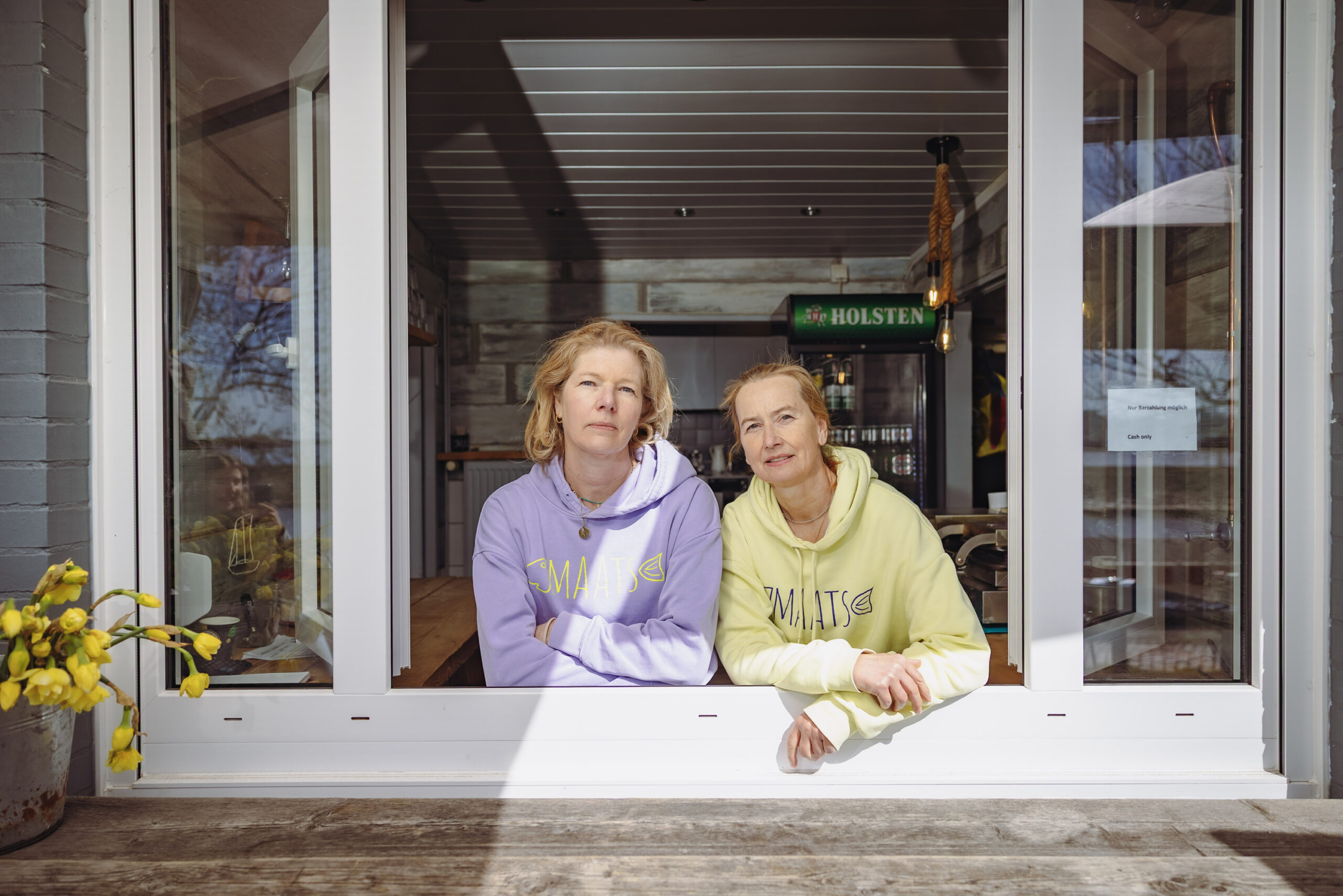 Annbritt Posselt und Stephanie Kaul stehen im Verkaufsfenster ihres Kiosks.