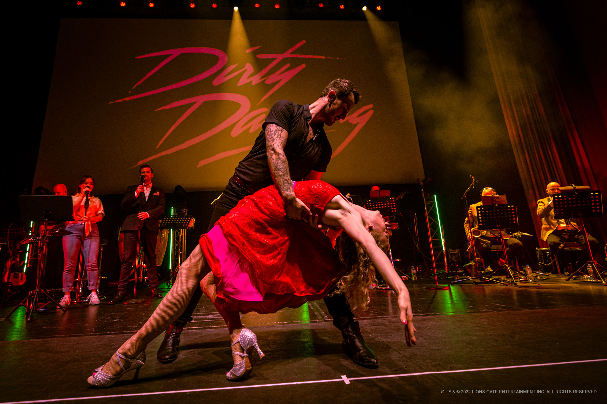 Ein Tänzer und eine Tänzerin stellen auf einer Bühne eine Tanzszene aus dem Film „Dirty Dancing“ nach.