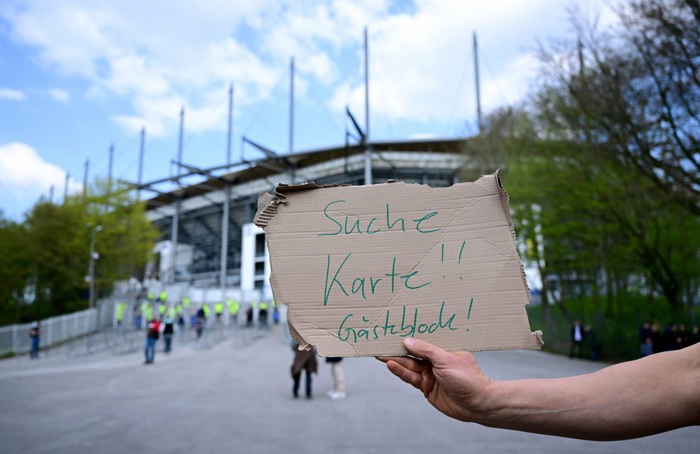Fan sucht mit einem Schild ein Ticket vor dem Volksparkstadion