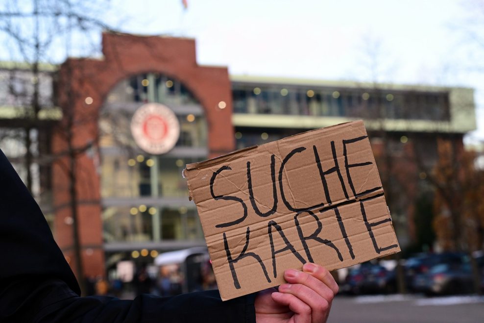 Fan sucht mit einem Schild ein Ticket vor dem Millerntor-Stadion