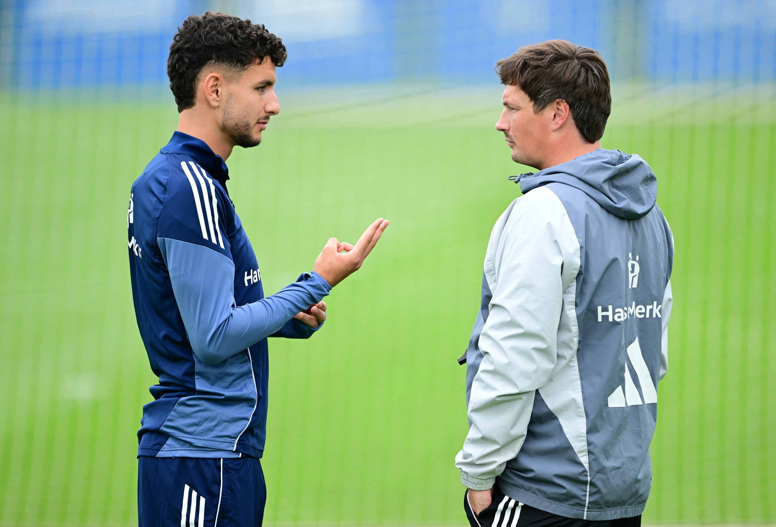 Daniel Elfadli steht auf dem Trainingsplatz neben HSV-Coach Merlin Polzin.