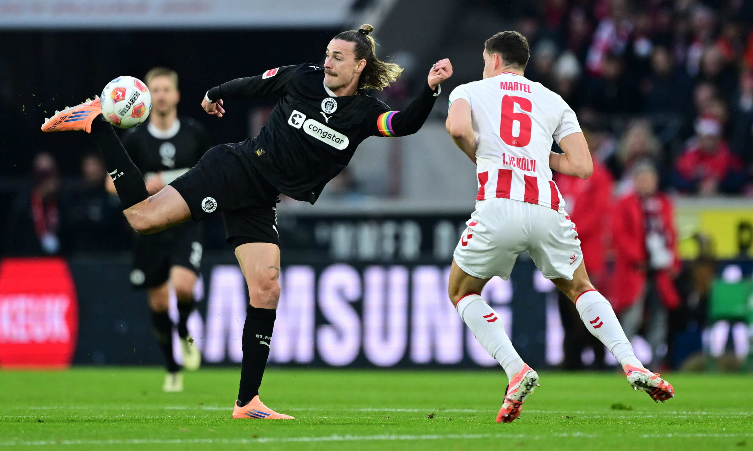 Jackson Irvine vom FC St. Pauli im Zweikampf mit Eric Martel von Köln