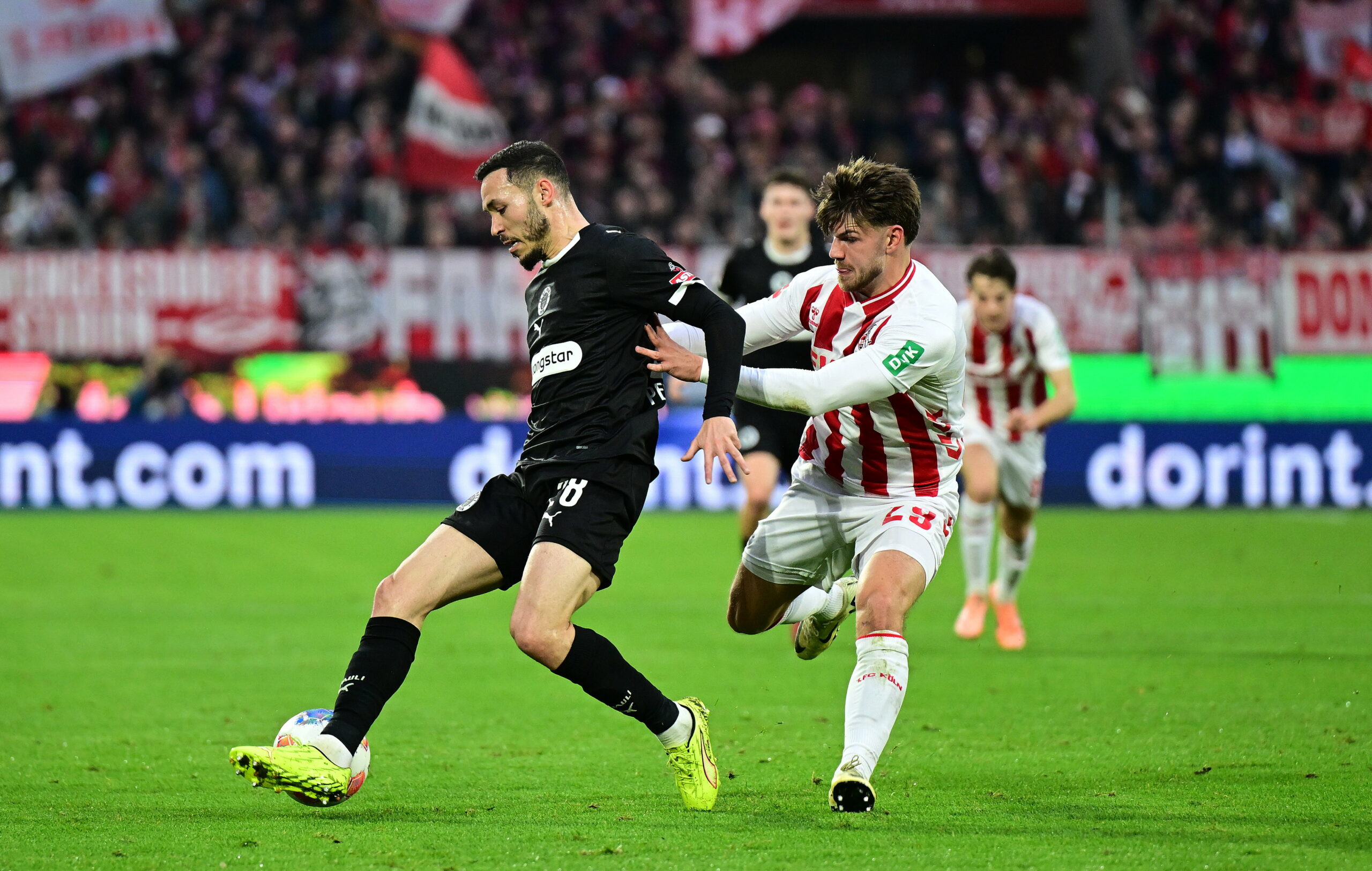 Mathias Pereira Lage von St. Pauli im Zweikampf mit Jan Thielmann von Köln vor einer TV-Kamera von Sky