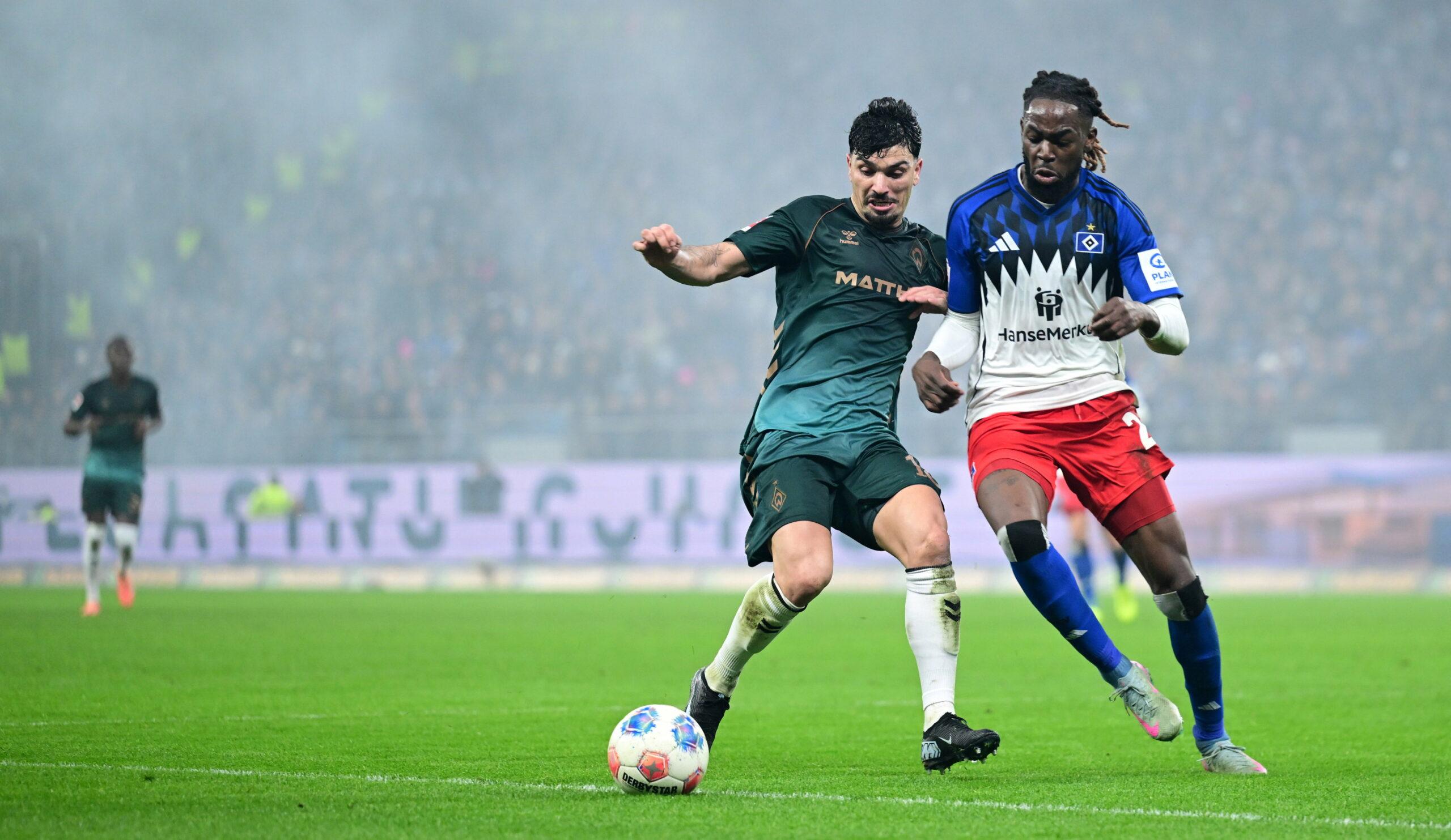 Jordan Torunarigha vom HSV im Zweikampf mit Cameron Puertas von Werder Bremen vor einer TV-Kamera von Sky