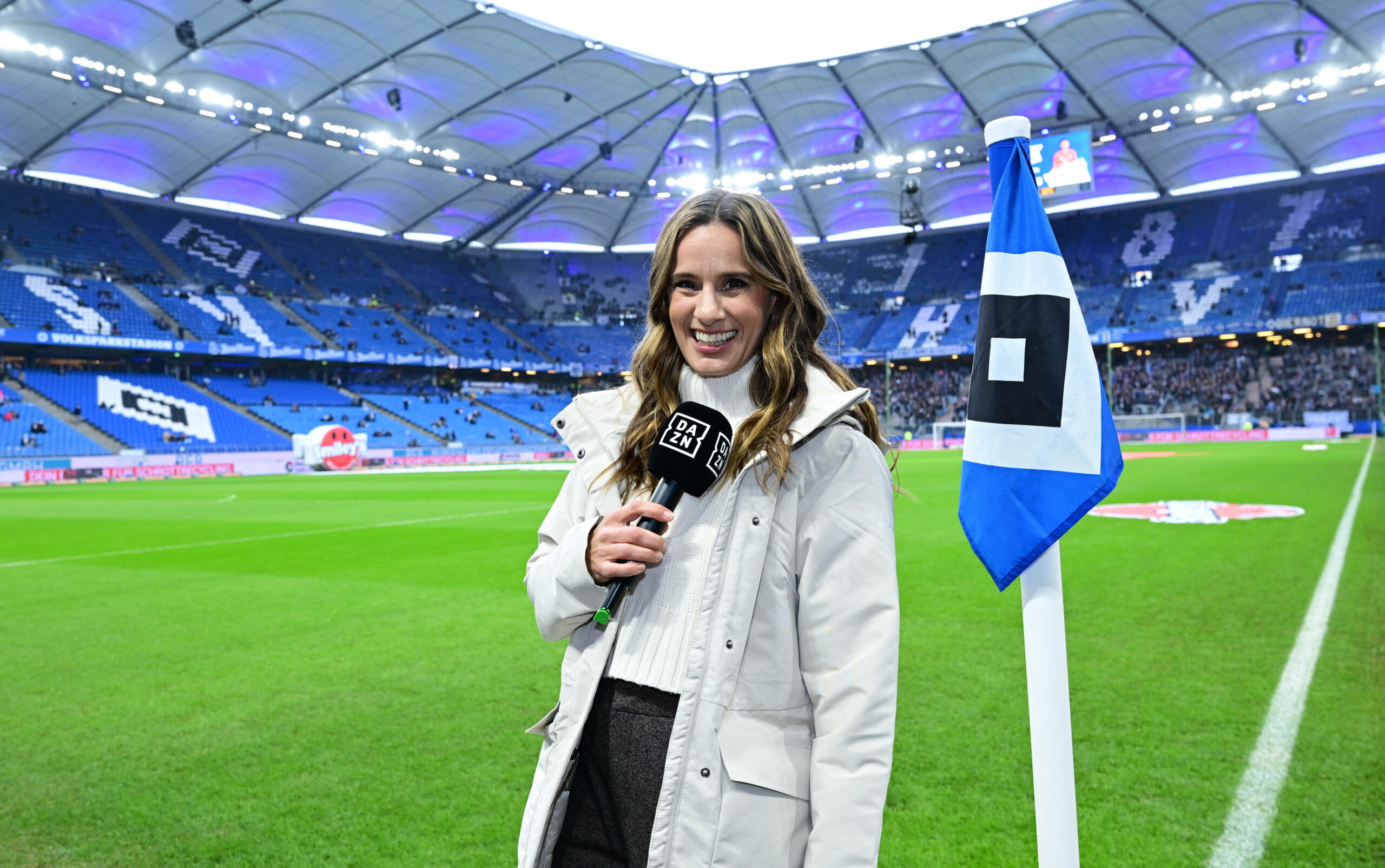 DAZN-Moderatorin Christina Rann vor einer Eckfahne des HSV im Volksparkstadion