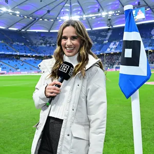 DAZN-Moderatorin Christina Rann vor einer Eckfahne des HSV im Volksparkstadion