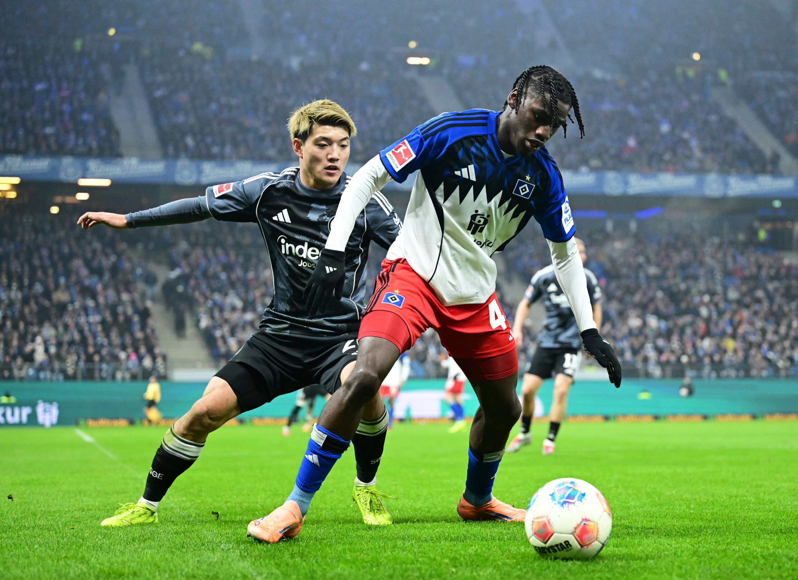 Fabio Baldé vom HSV im Zweikampf mit Ritsu Doan von Frankfurt vor einer TV-Kamera von Sky