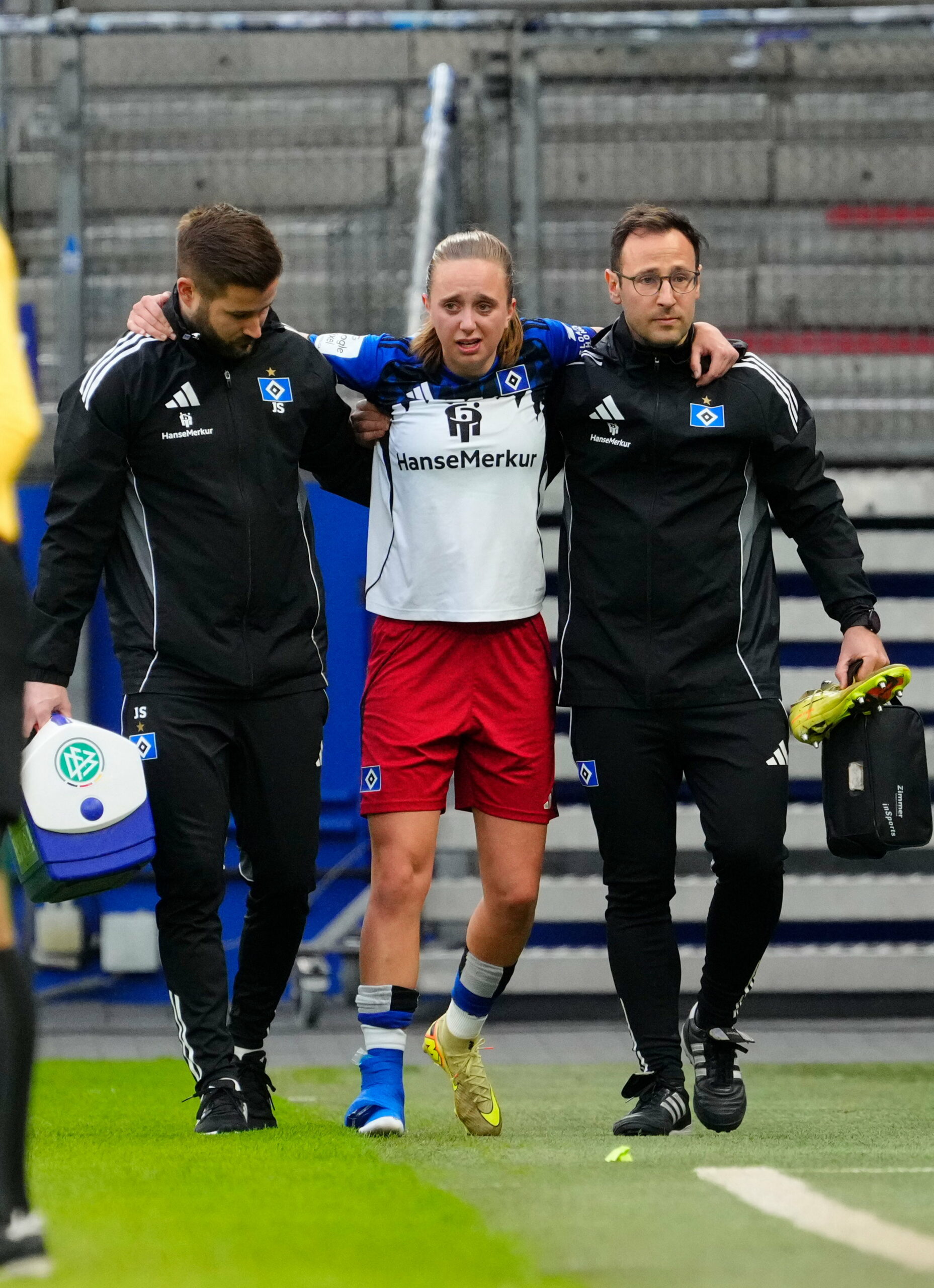 Victoria Schulz humpelt gestützt von den Teamärzten vom Platz