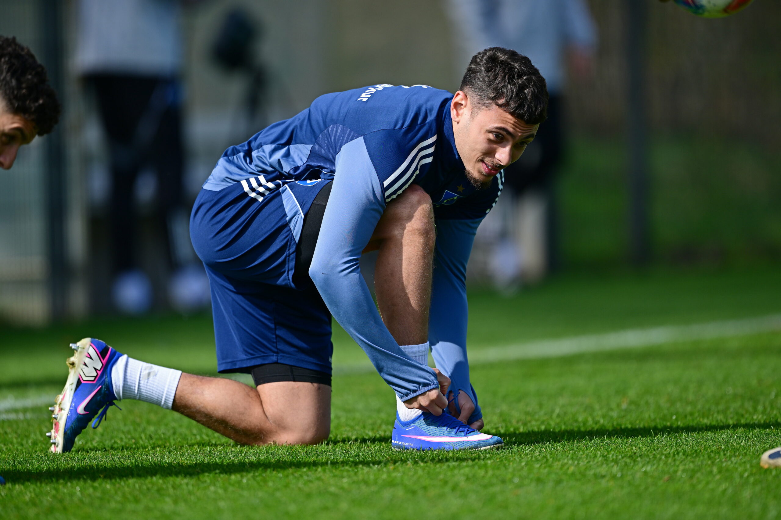 William Mikelbrencis bindet sich im HSV-Training seine Schuhe