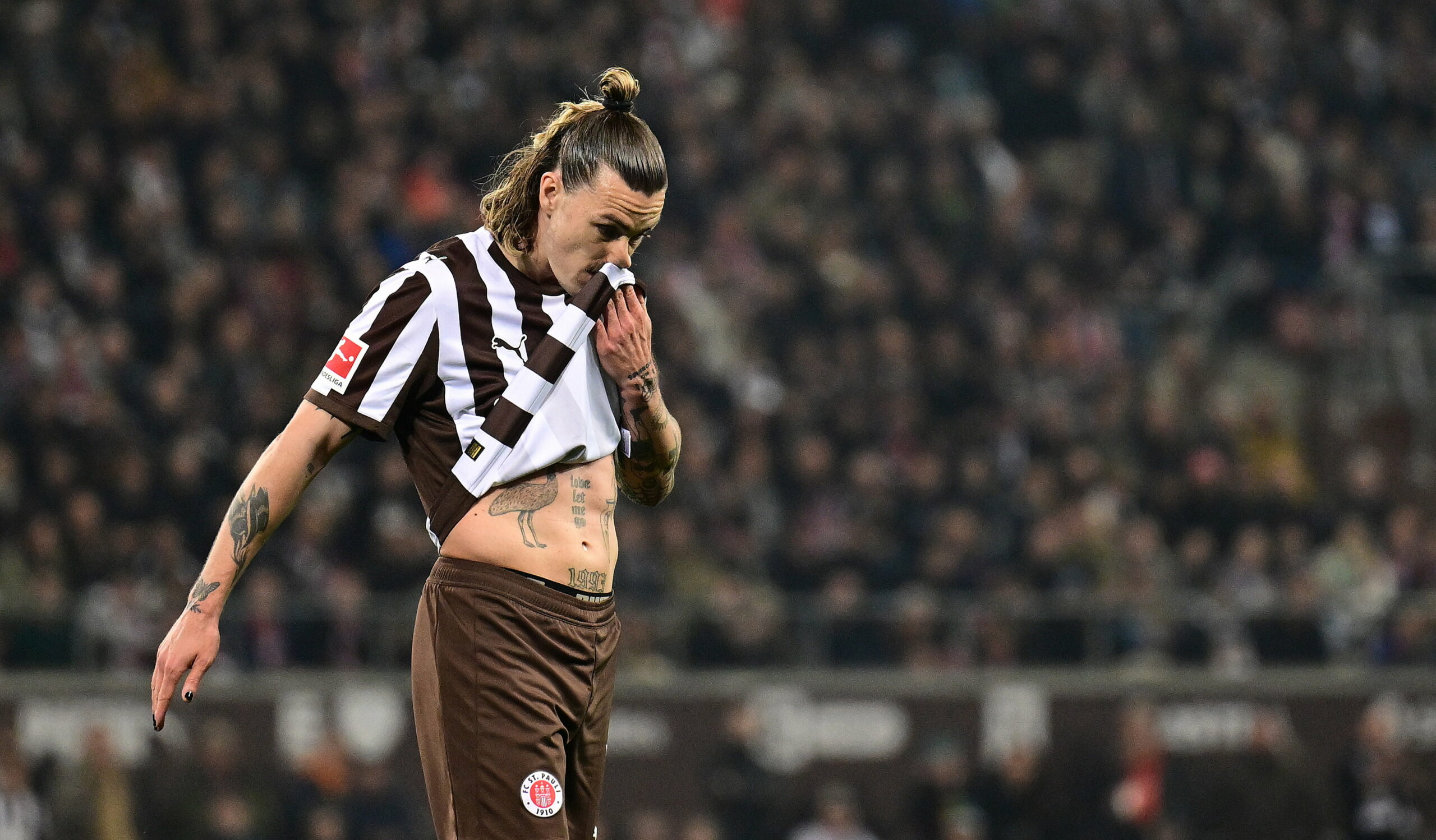 Jackson Irivne wischt sich mit seinem Trikot übers Gesicht.