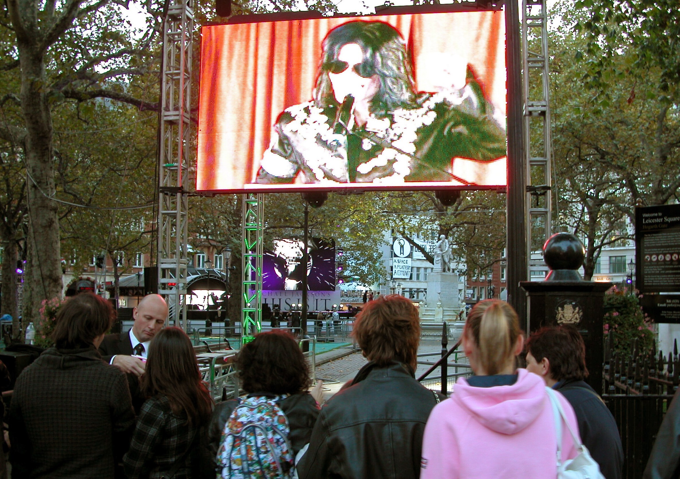 Fans stehen vor dem Start des Michael-Jackson-Films auf dem Leicester Square in London vor einer Leinwand.