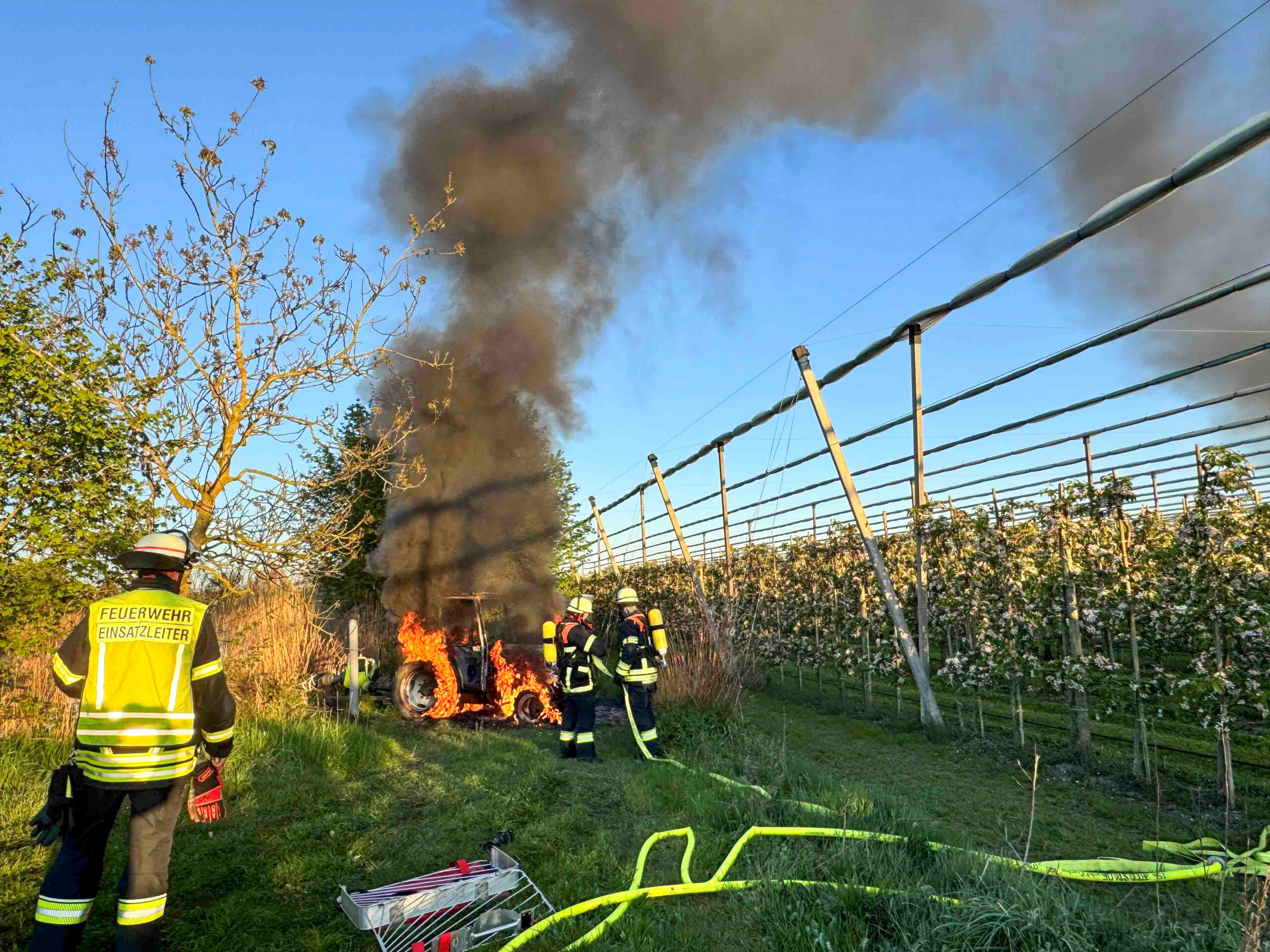 Ein Traktor im Alten Land steht in Flammen.