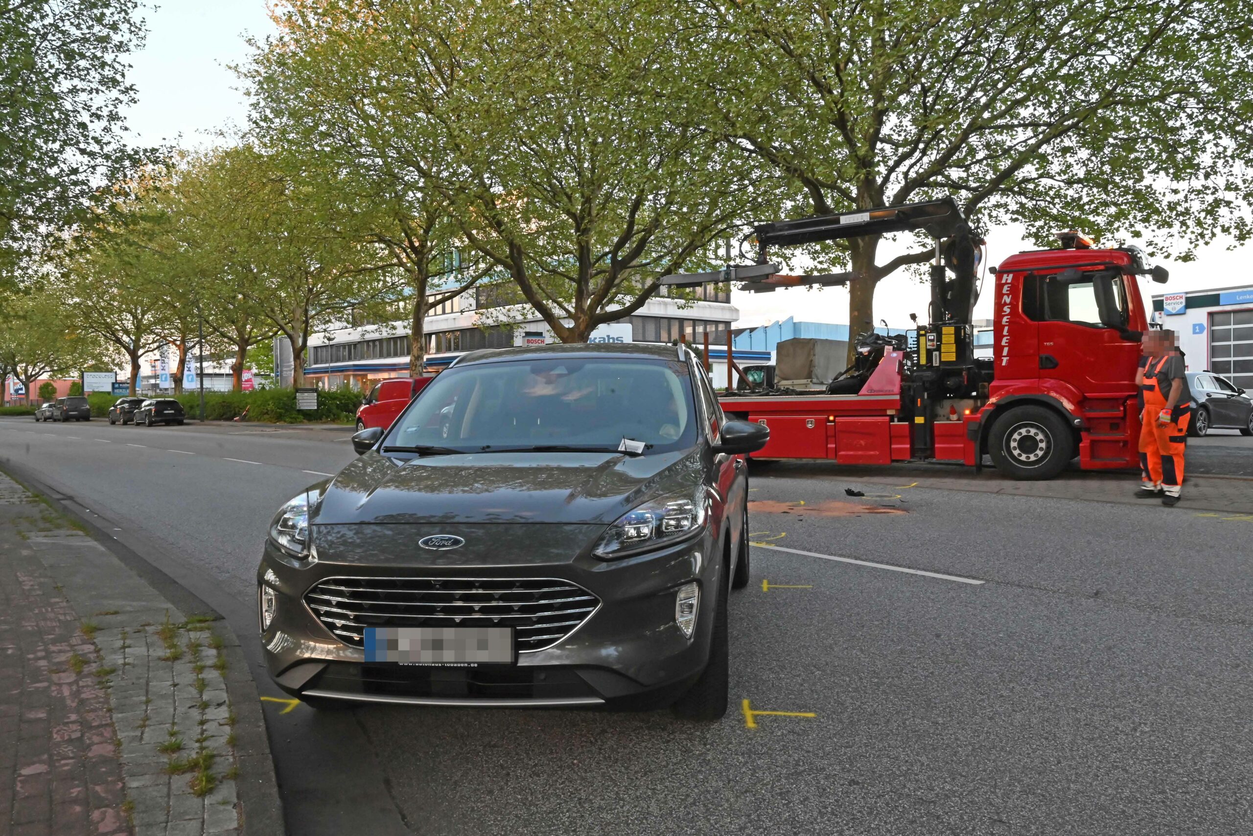 Das am Unfall beteiligte Pkw. Im Hintergrund wird das Motorrad abgeschleppt.