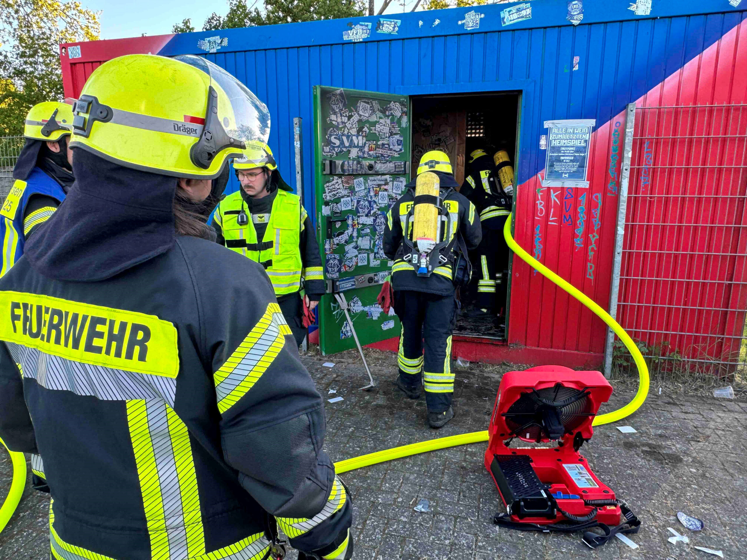 Feuerwehrkräfte löschen den Brand im Inneren des Toiletten-Containers.