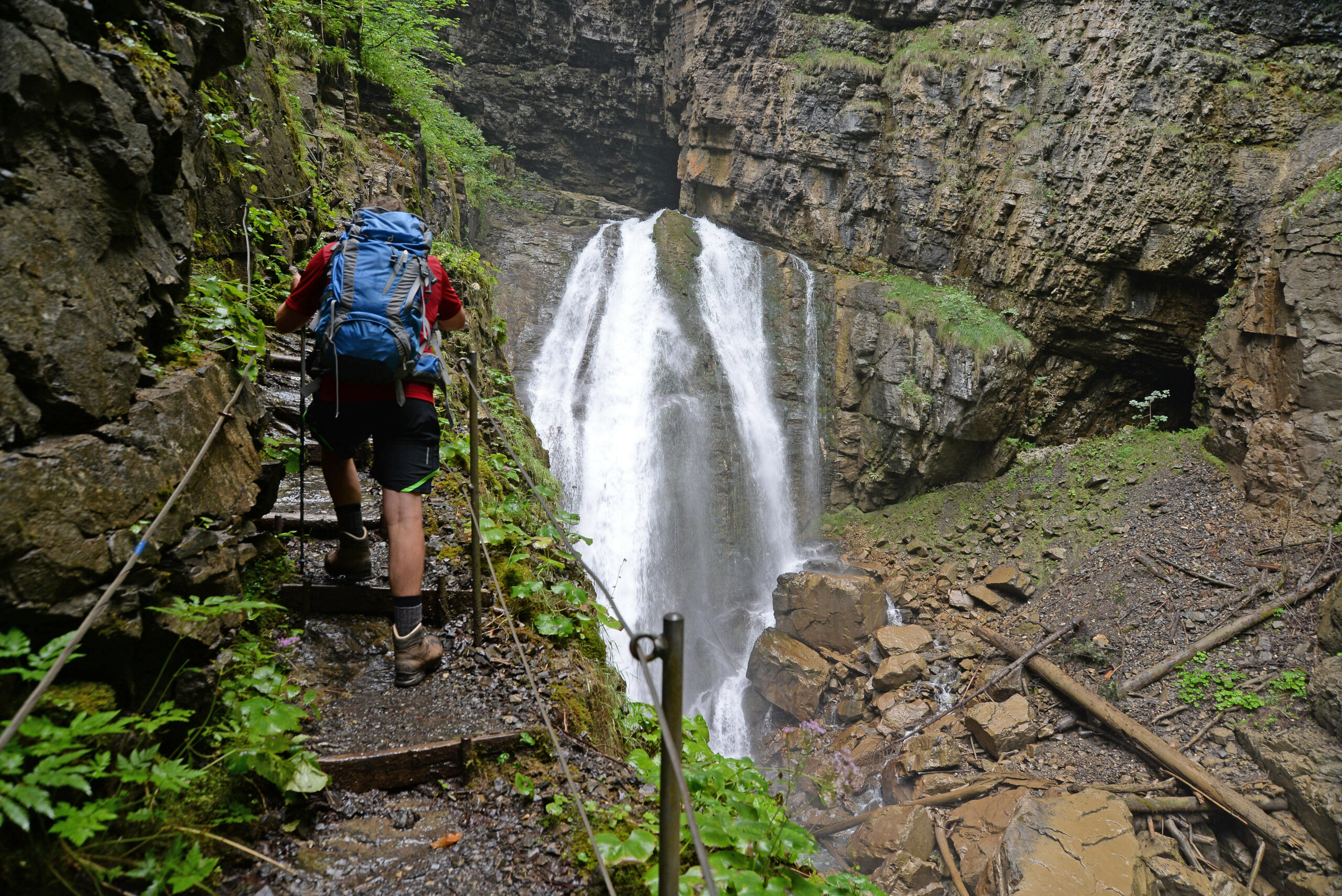 Ein Wanderer an einem Wasserfall im österreichischen Vorarlberg.