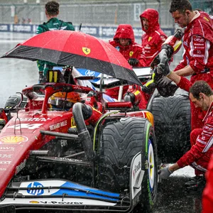 Der Ferrari von Lewis Hamilton wird mit einem Schirm vor dem Regen geschützt.