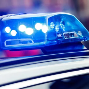 Das eingeschaltete Blaulicht ist auf dem Dach von einem Einsatzfahrzeug der Polizei zu sehen.