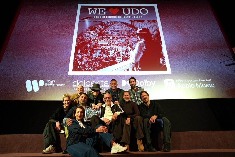 Udo Lindenberg präsentiert sich mit anderen Künstlern auf einer Bühne unter dem neuen Albumcover