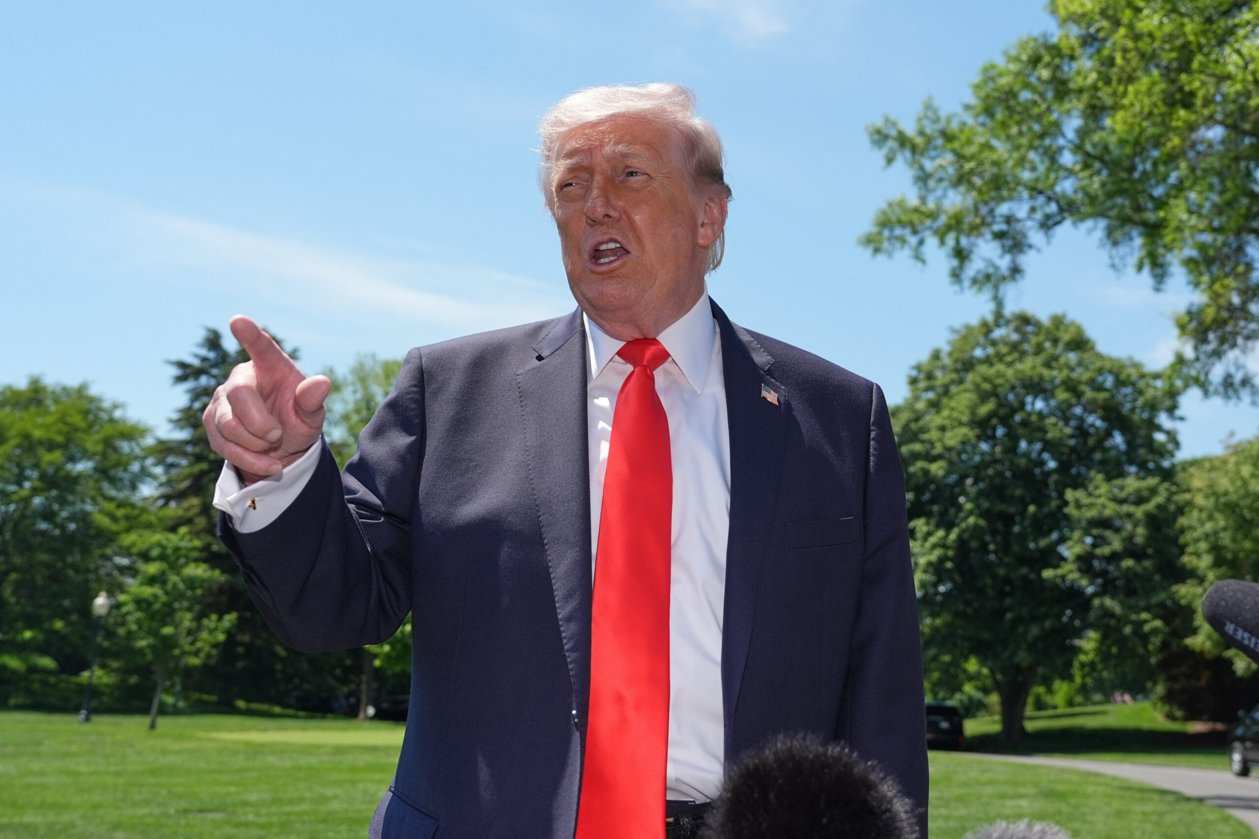Trump mit rotem Schlips vor blauem Himmel