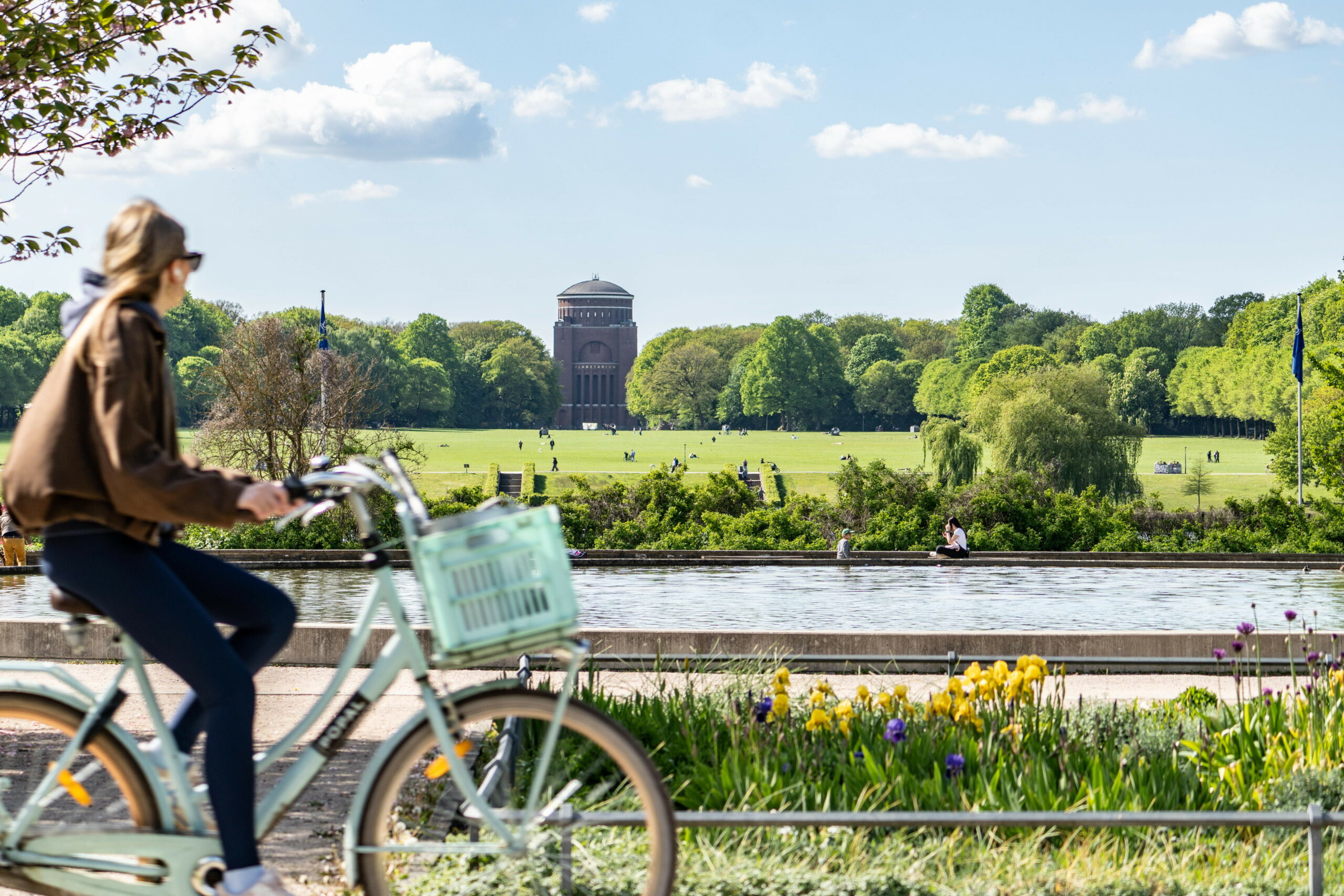 Eine Frau fährt mit einem Fahrrad im Hamburger Stadtpark.