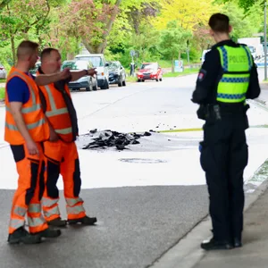 Einsatzkräfte vor aufgeplatzter Straße