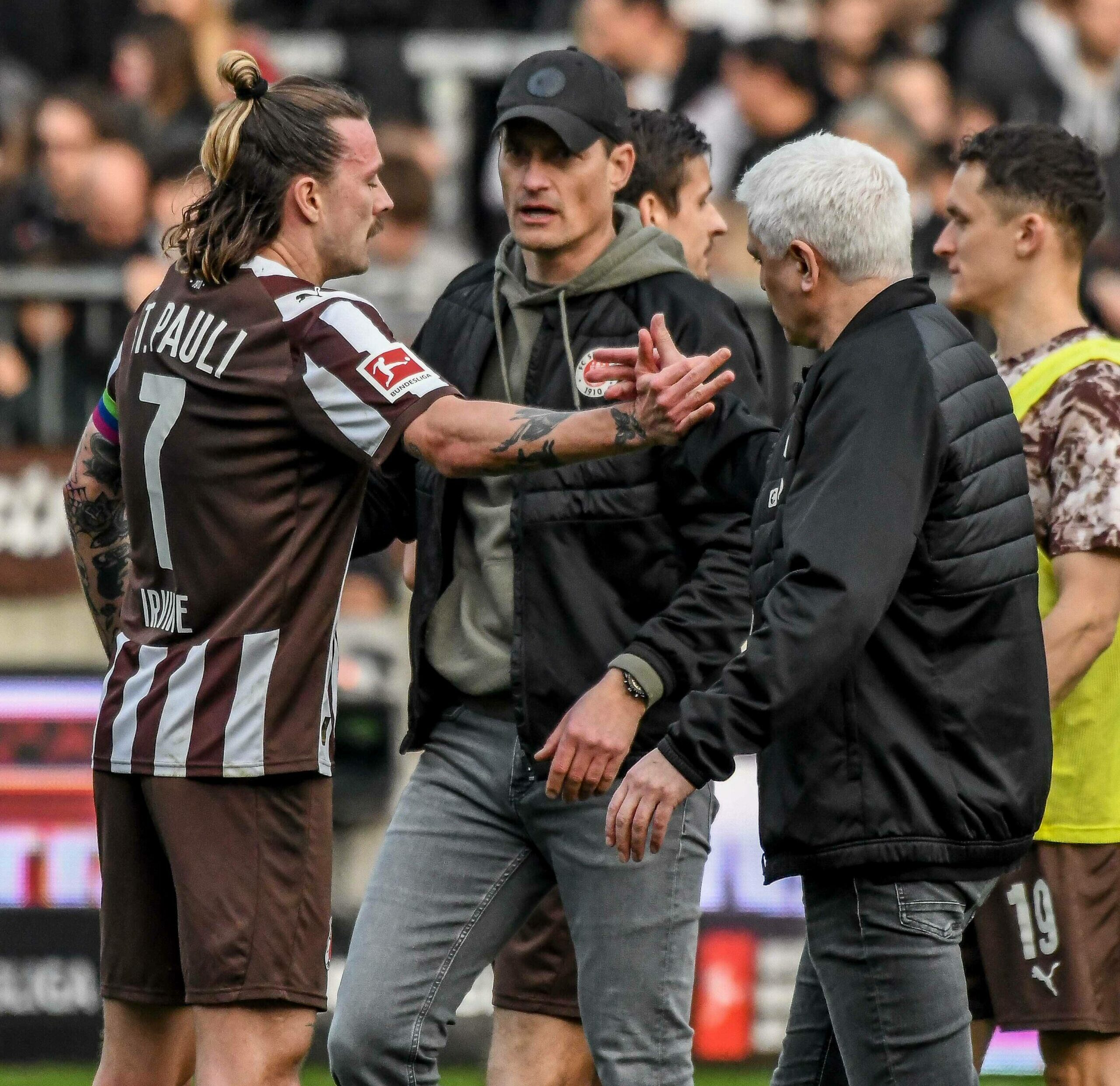 St. Pauli-Kapitän Jackson Irvine mit Trainer Alexander Blessin und Sportchef Andreas Bornemann.