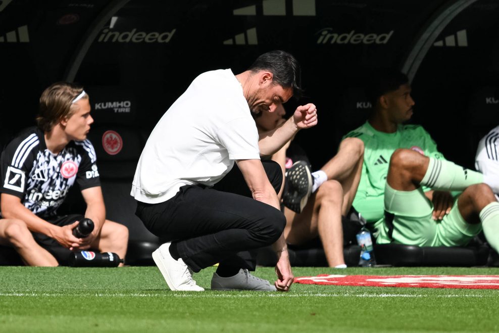 Frankfurt-Trainer Albert Riera kniet mit gesenktem Haupt an der Seitenlinie.