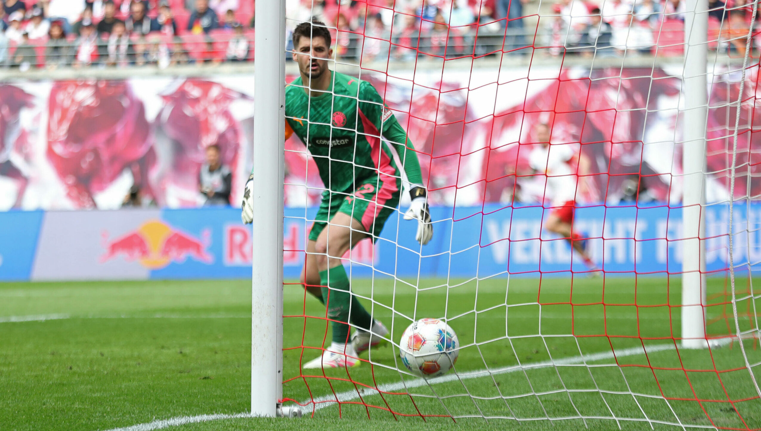 St. Pauli-Keeper Nikola Vasilj schaut dem Schuss zum 1:0-Führung von RB Leipzig hinterher