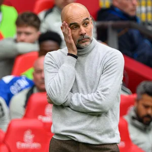 Pep Guardiola grübelt mit Hand an der Wange.