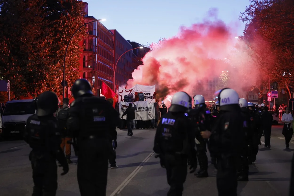 Dichter roter Rauch auf der Max-Brauer-Allee. Demonstranten zündeten Pyrotechnik.