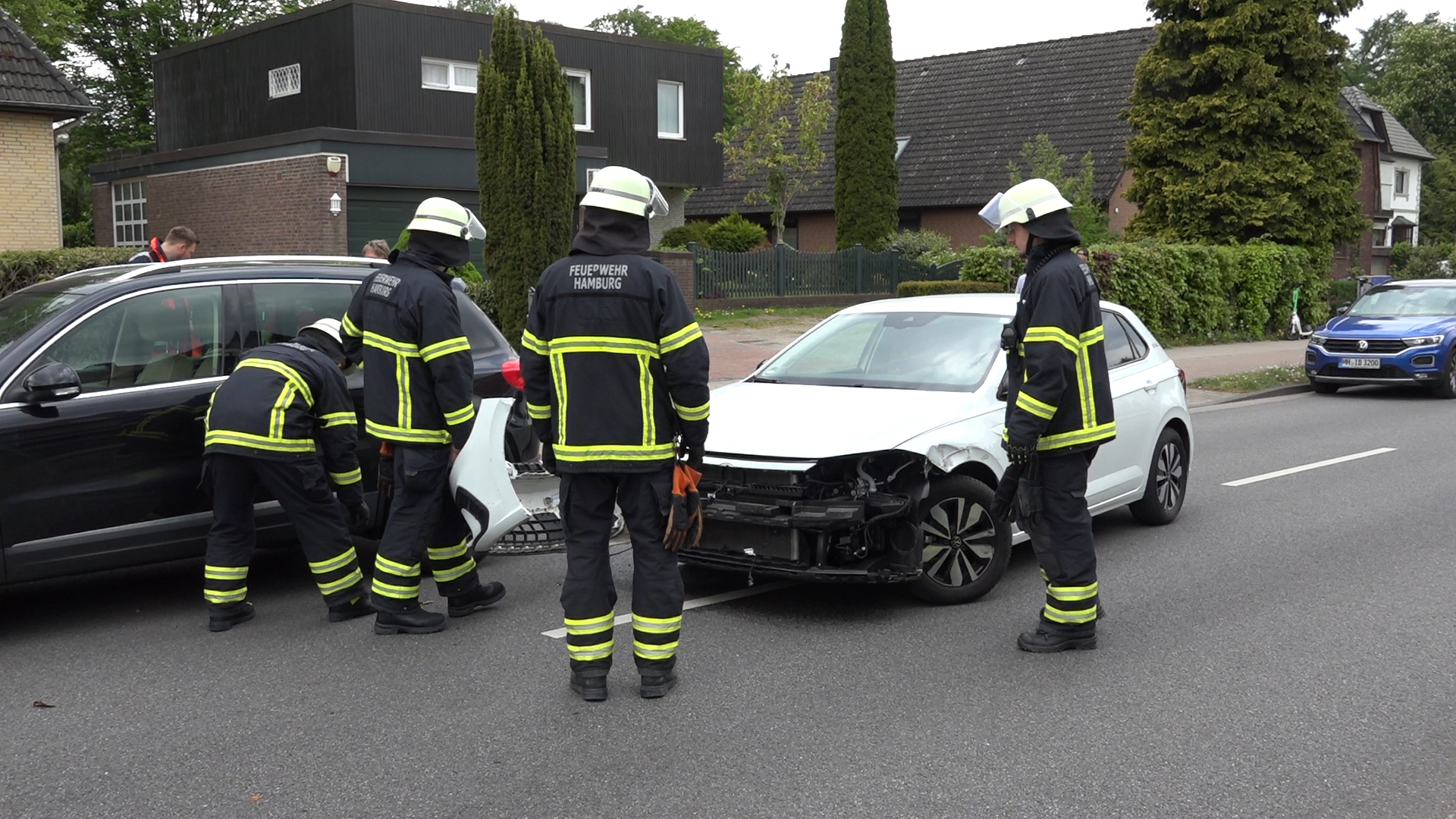 Feuerwehrkräfte vor dem am Unfall beteiligten VW.