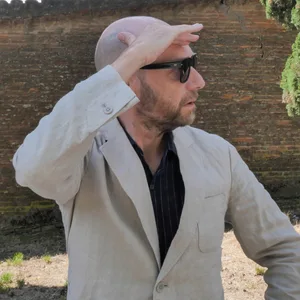 Ein Mann mit Sonnenbrille schaut in die Ferne.