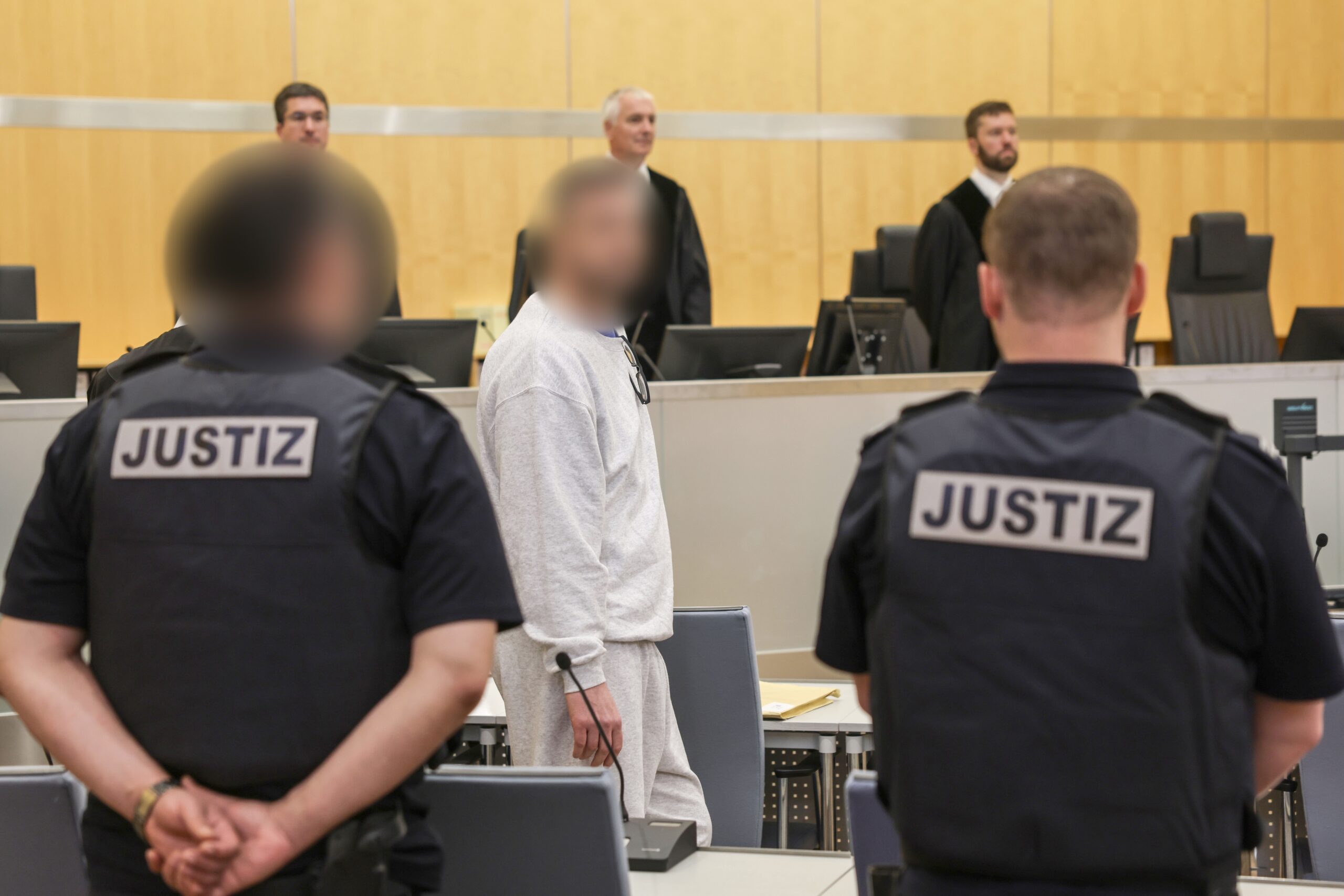 Der Angeklagte (M.) im grauen Jogginganzug vor dem Düsseldorfer Oberlandesgericht. Der 50-Jährige aus der rechtsextremen Szene in Dortmund soll zu Attentaten auf bekannte Politiker aufgerufen haben.