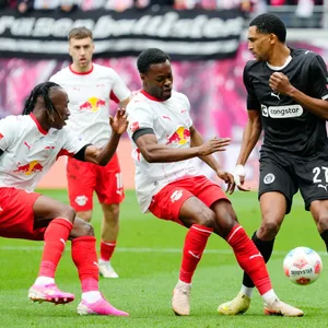 Yan Diomande und Ridle Baku von RB Leipzig im Zweikampf mit Andreas Hountondji von St. Pauli